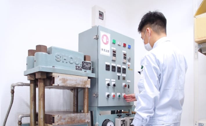 単板式自動プレス機を操作する人